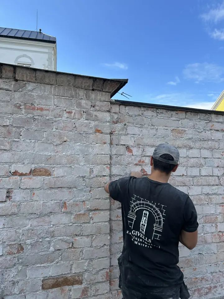 Teodor arbetar på en gammal tegelmur en solig dag